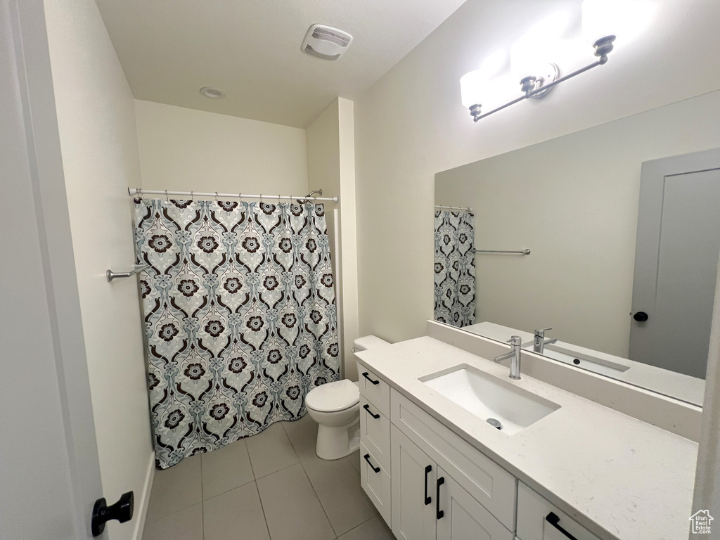 Full bathroom featuring tile patterned flooring, vanity, toilet, a shower with shower curtain, and visible vents