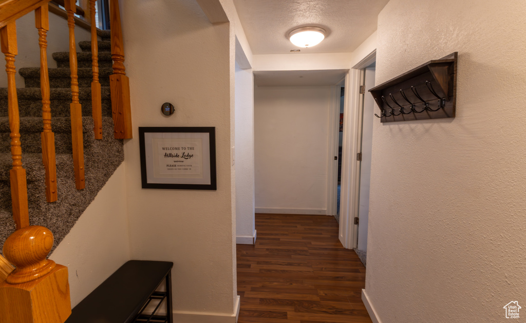 Hallway featuring stairs, baseboards, and dark wood-type flooring