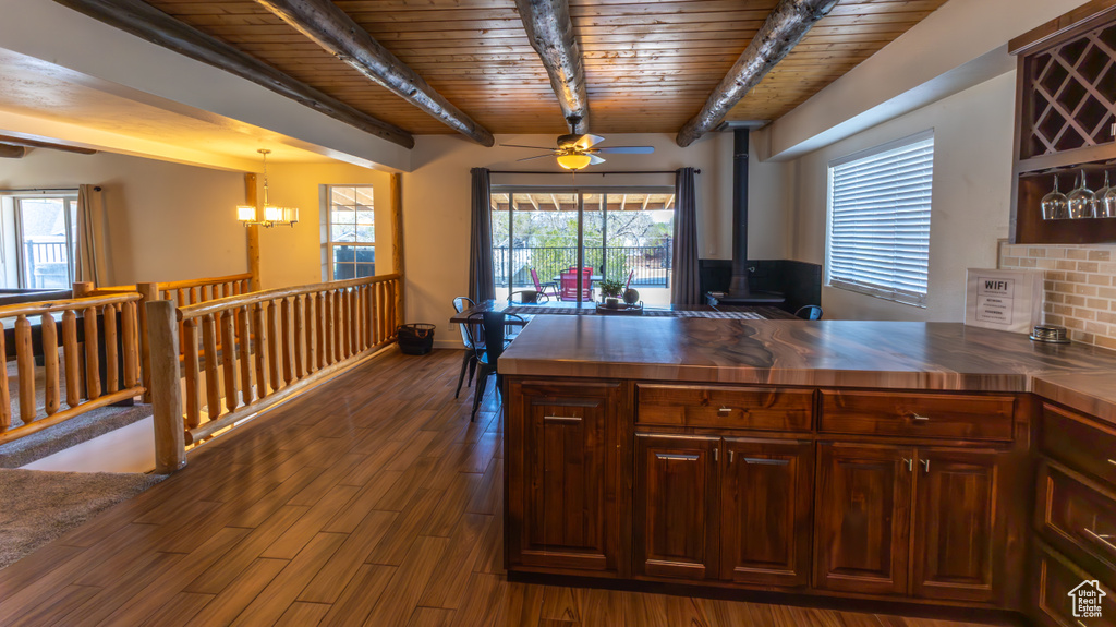 Kitchen with wooden counters, a wood stove, beam ceiling, wooden ceiling, and ceiling fan with notable chandelier