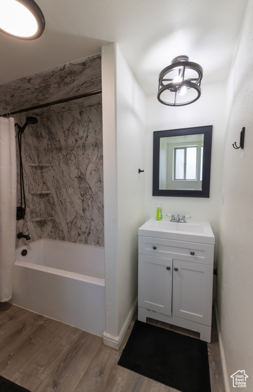 Full bath featuring vanity, wood finished floors, and shower / tub combo