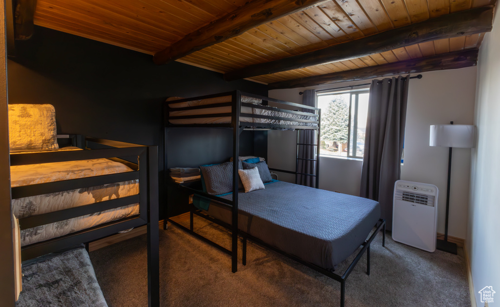 Carpeted bedroom featuring beamed ceiling and wooden ceiling