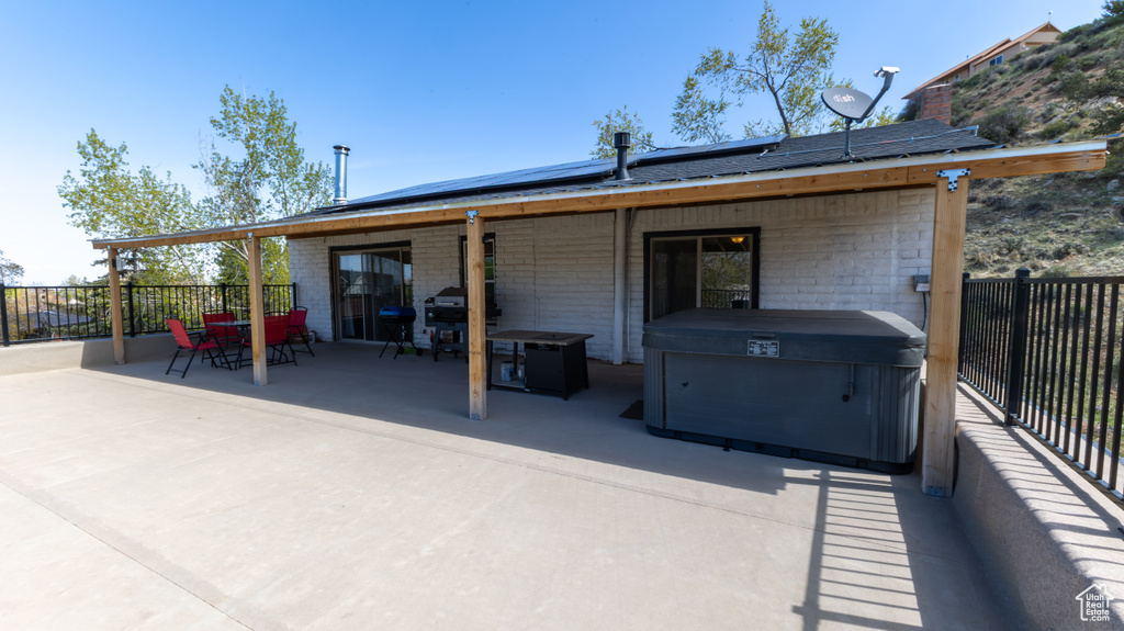 Exterior space featuring roof mounted solar panels, fence, a patio, and outdoor dining space