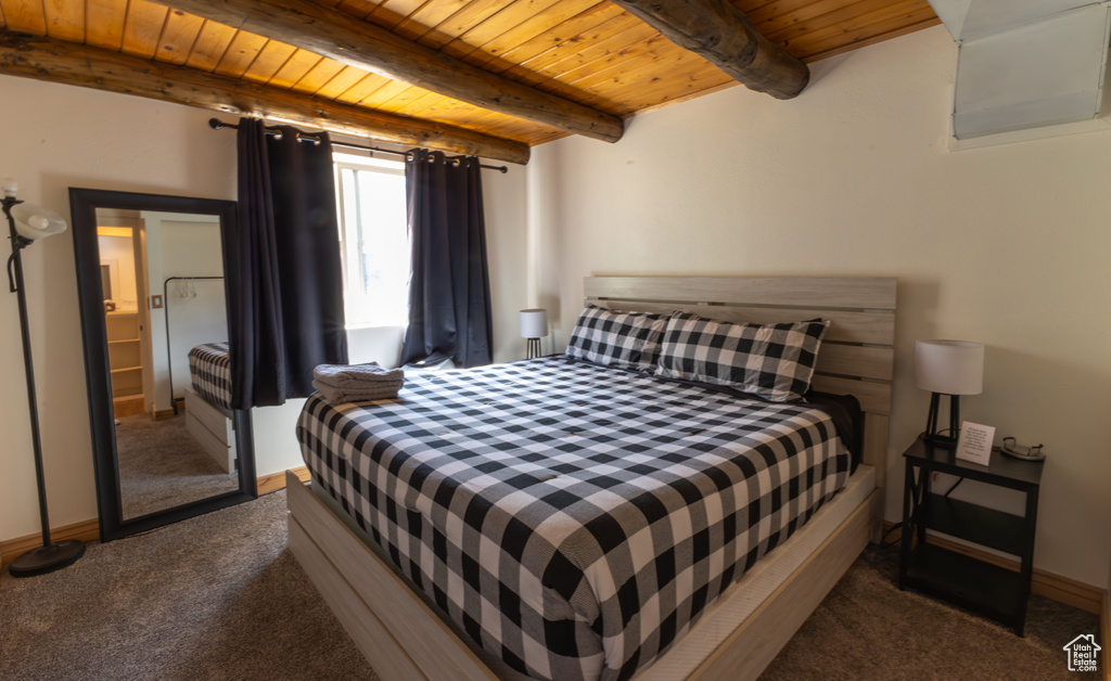 Carpeted bedroom with baseboards, wood ceiling, and beamed ceiling