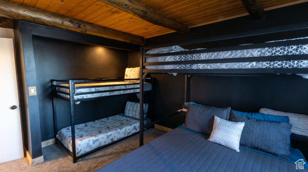 Carpeted bedroom featuring wood ceiling and beamed ceiling