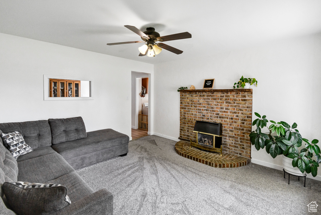 Living area featuring baseboards, carpet, and a ceiling fan