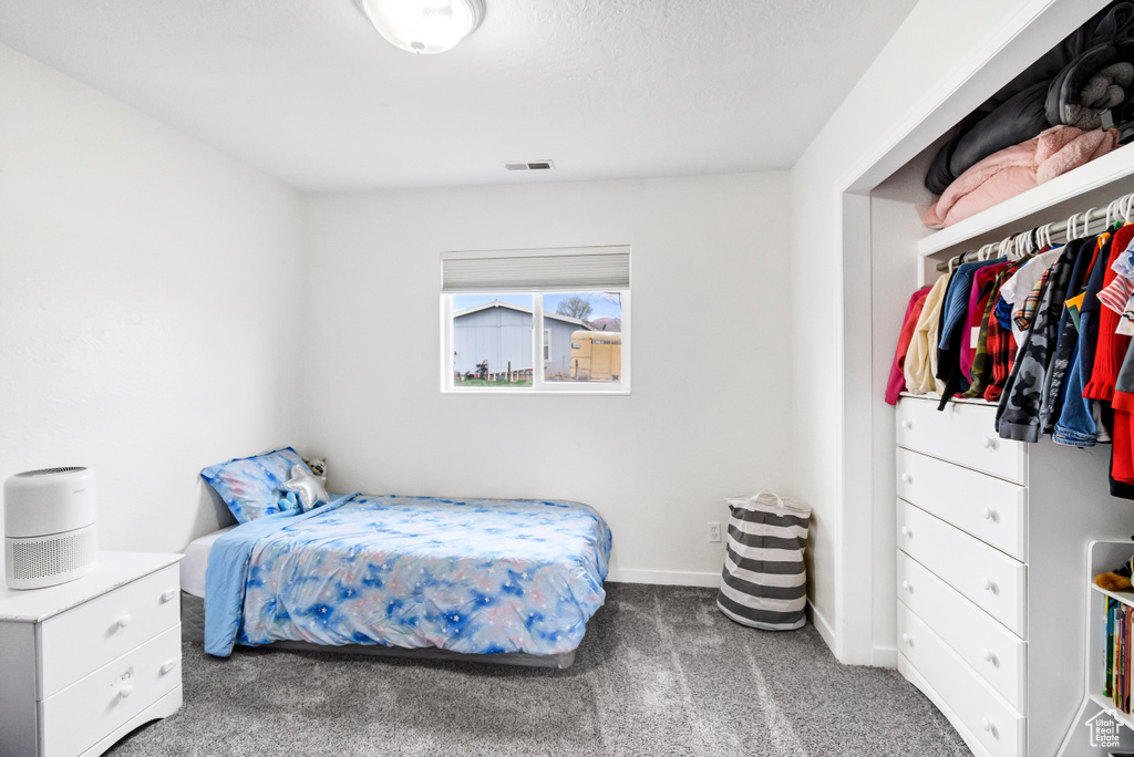 Carpeted bedroom with visible vents and baseboards
