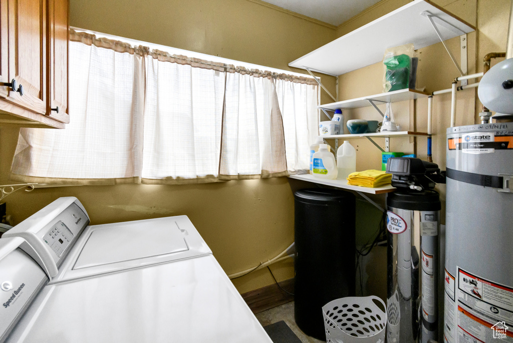 Clothes washing area with cabinet space, water heater, and washing machine and dryer