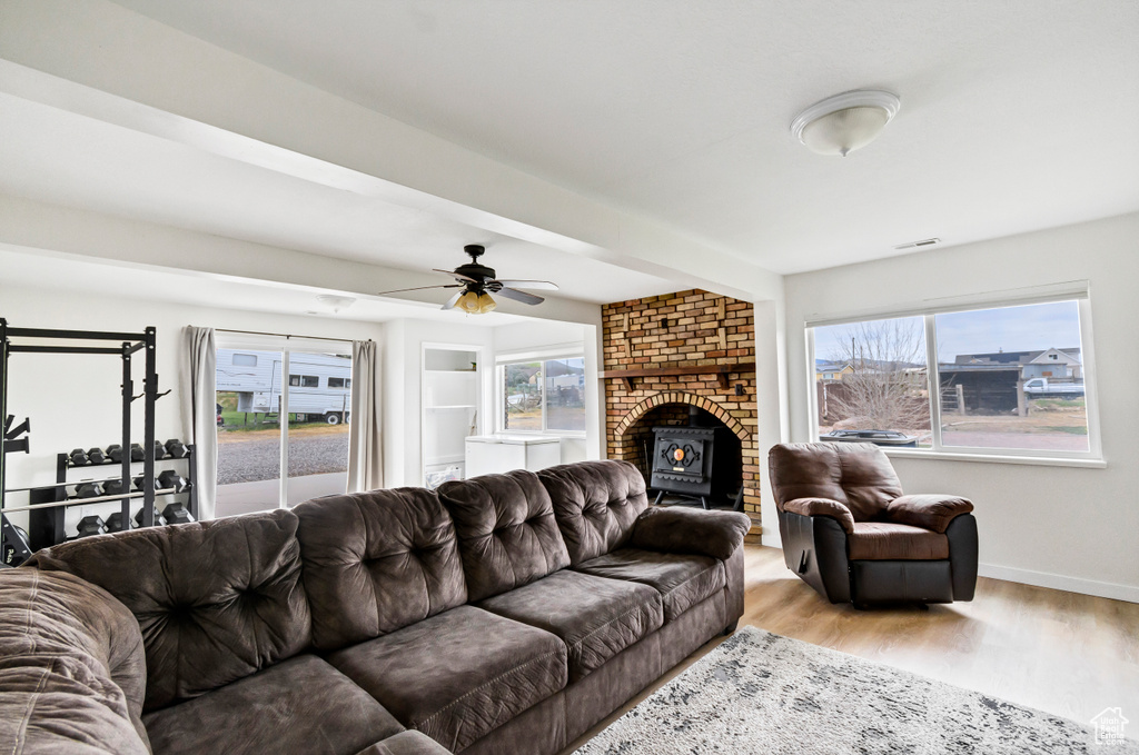 Living room with a ceiling fan, baseboards, a wealth of natural light, and light wood-type flooring