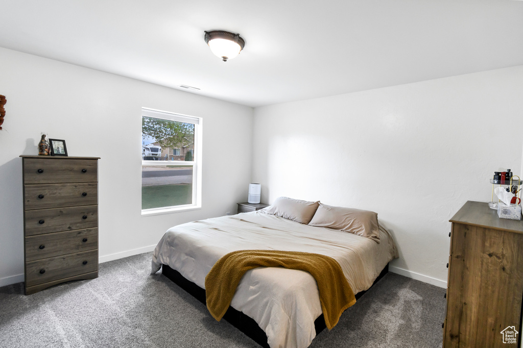 Bedroom with carpet floors, baseboards, and visible vents
