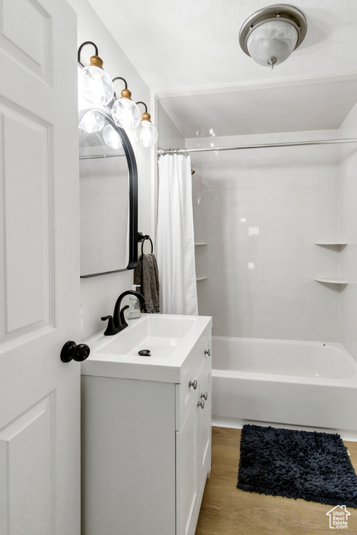 Full bathroom featuring vanity, wood finished floors, and shower / bath combo