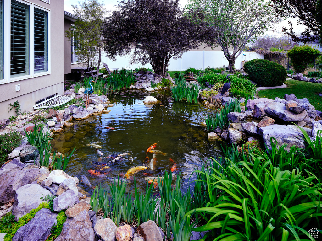 Details featuring fence and a garden pond