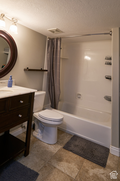 Full bath with a textured ceiling, visible vents, vanity, toilet, and shower / tub combo with curtain