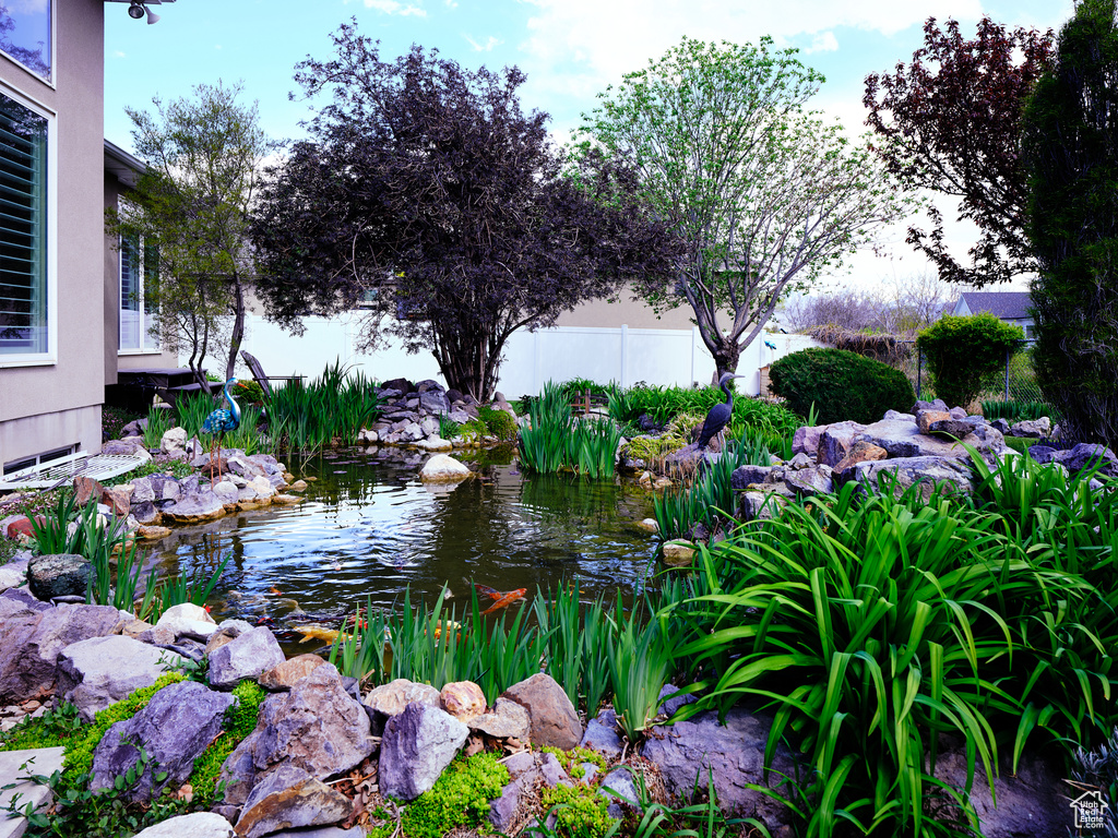 View of yard featuring a garden pond and fence