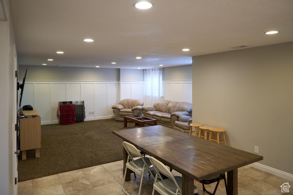 Dining space with a decorative wall, recessed lighting, and light colored carpet