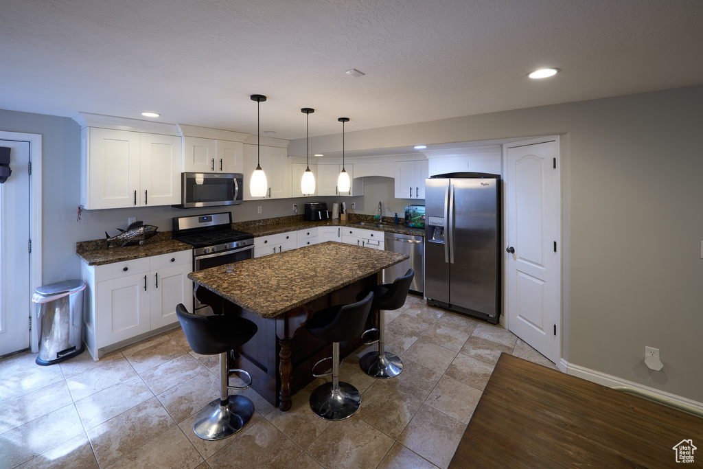 Kitchen featuring a sink, appliances with stainless steel finishes, white cabinets, and recessed lighting