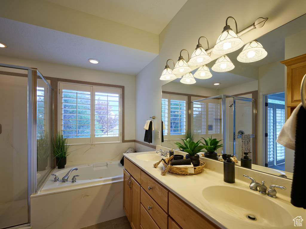 Full bathroom with a garden tub, a sink, double vanity, and a shower stall