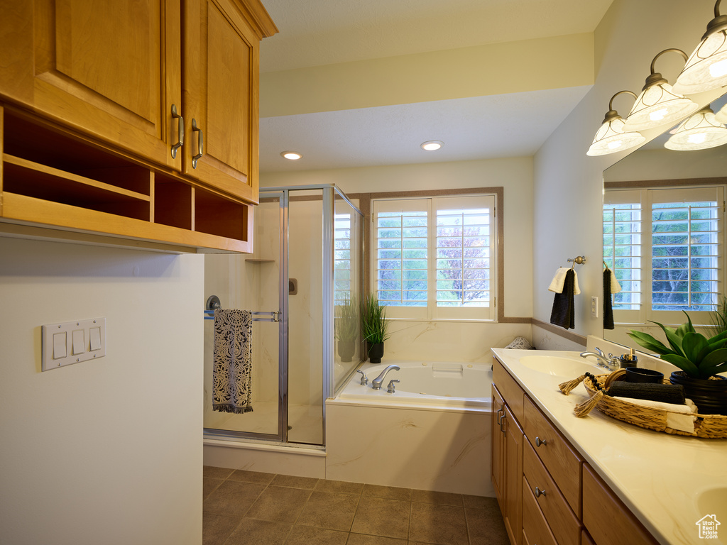 Full bath featuring double vanity, tile patterned flooring, a stall shower, and a garden tub