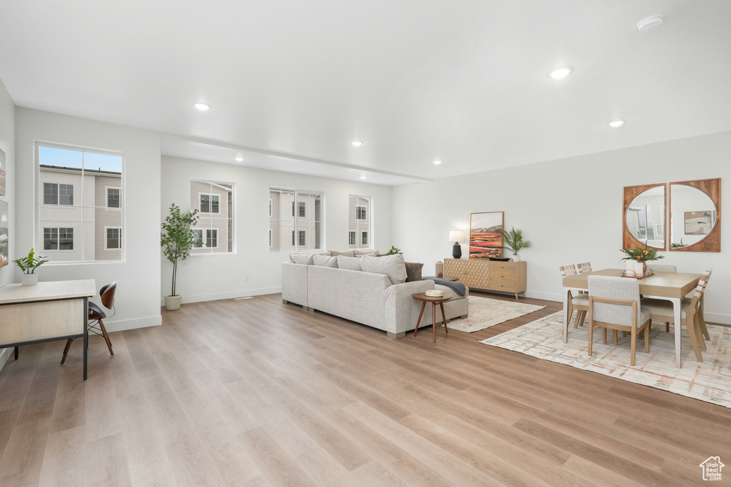 Living area with recessed lighting, light wood-style floors, and baseboards