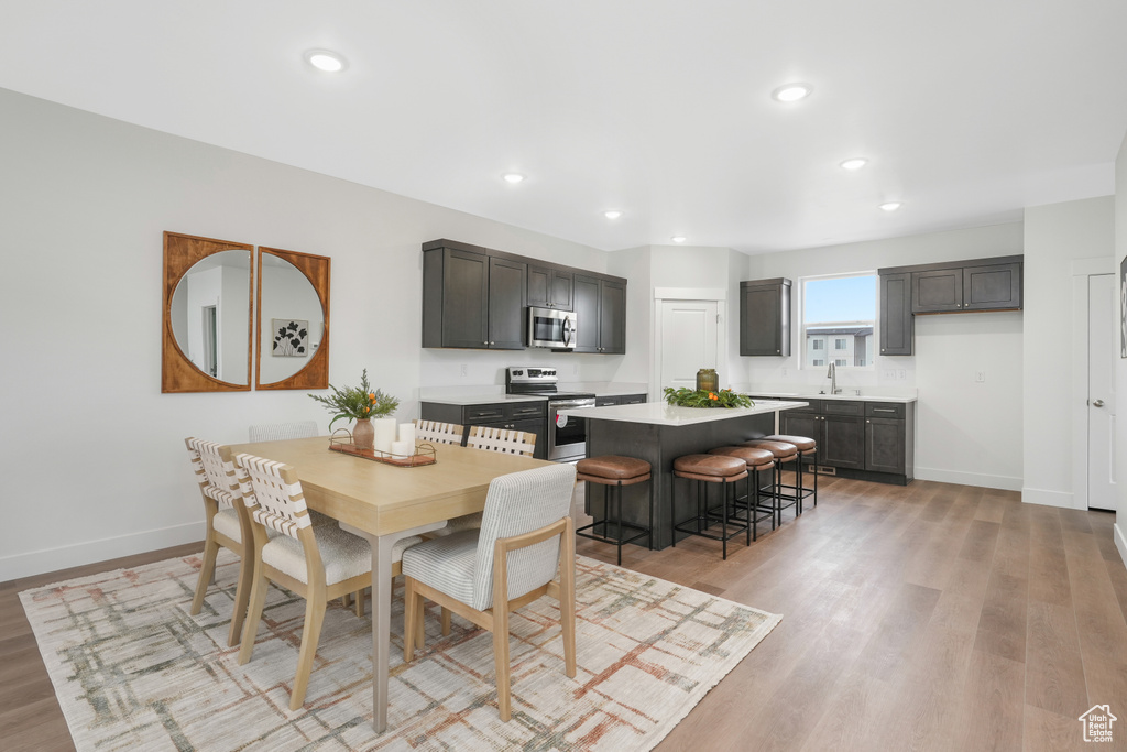 Dining room featuring recessed lighting, baseboards, and light wood-type flooring