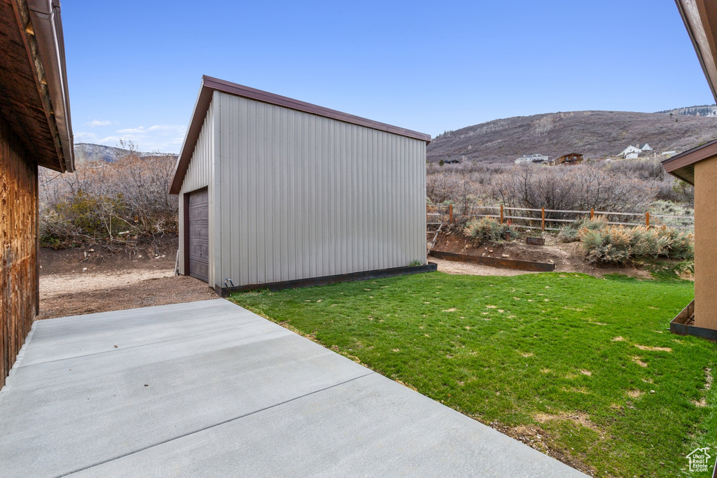 View of yard with a mountain view, an outdoor structure, and a detached garage