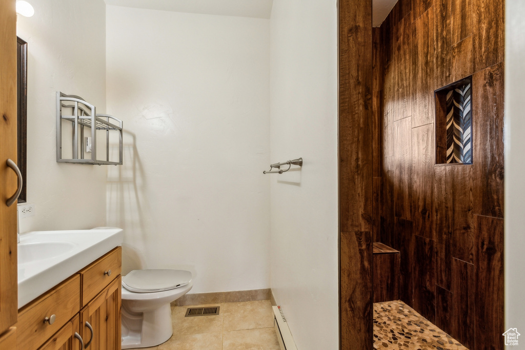 Bathroom with tile patterned flooring, vanity, toilet, baseboards, and visible vents