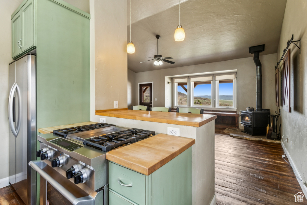 Kitchen featuring dark wood-style flooring, stainless steel appliances, wood counters, and green cabinets
