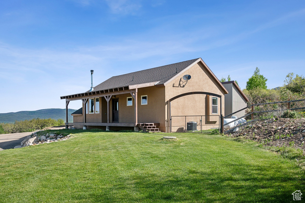 Rear view of property with cooling unit, stucco siding, and a mountain view