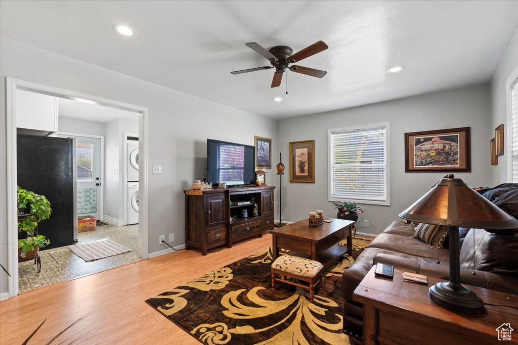 Living area with a wealth of natural light, stacked washer and clothes dryer, and a ceiling fan