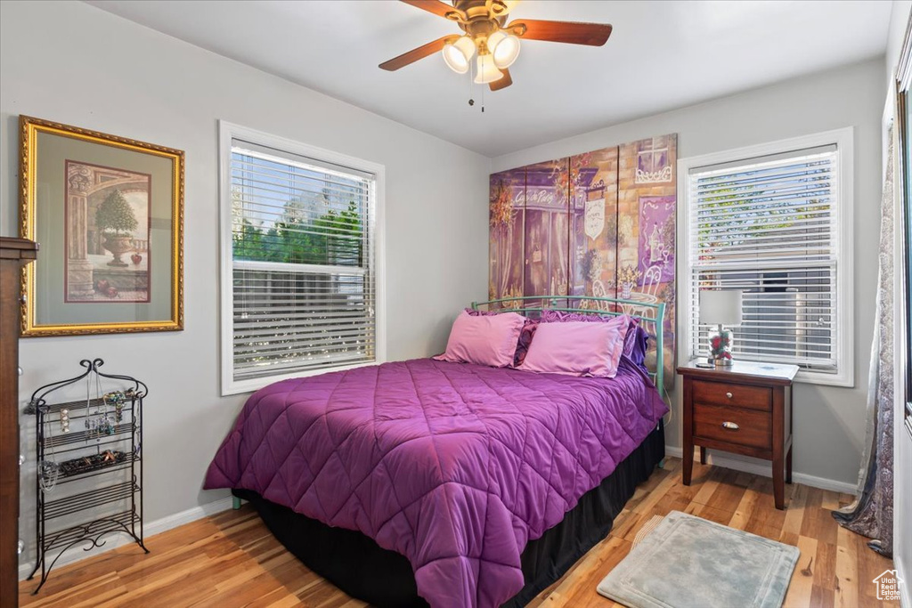 Bedroom featuring multiple windows, wood finished floors, and baseboards