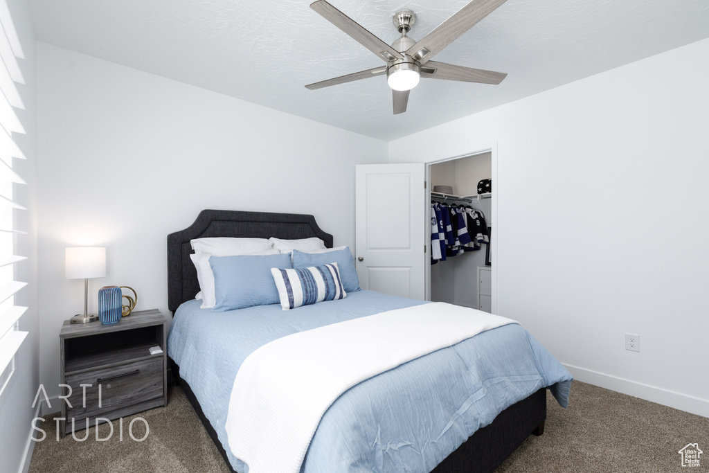 Carpeted bedroom featuring a ceiling fan and baseboards