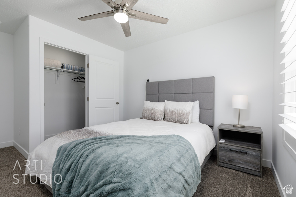 Bedroom with dark carpet, ceiling fan, a closet, and baseboards