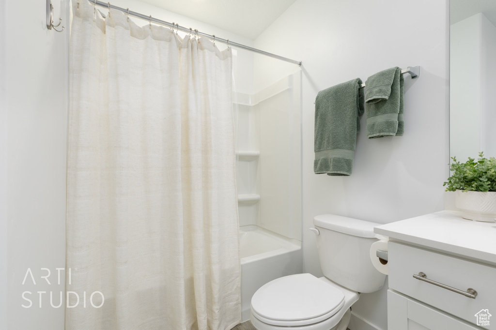 Full bathroom with shower / tub combo with curtain, toilet, and vanity