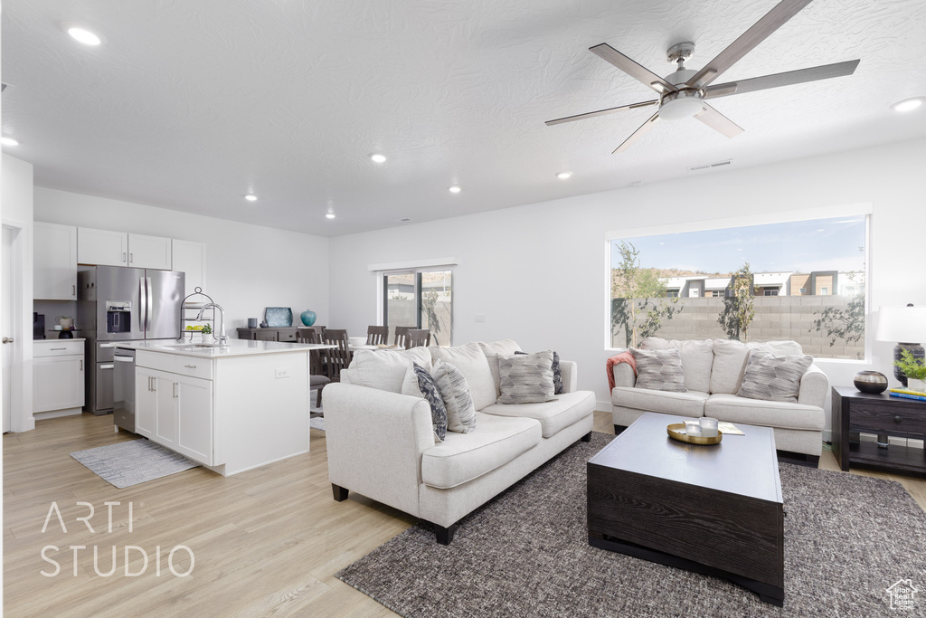 Living area with recessed lighting and light wood-style flooring