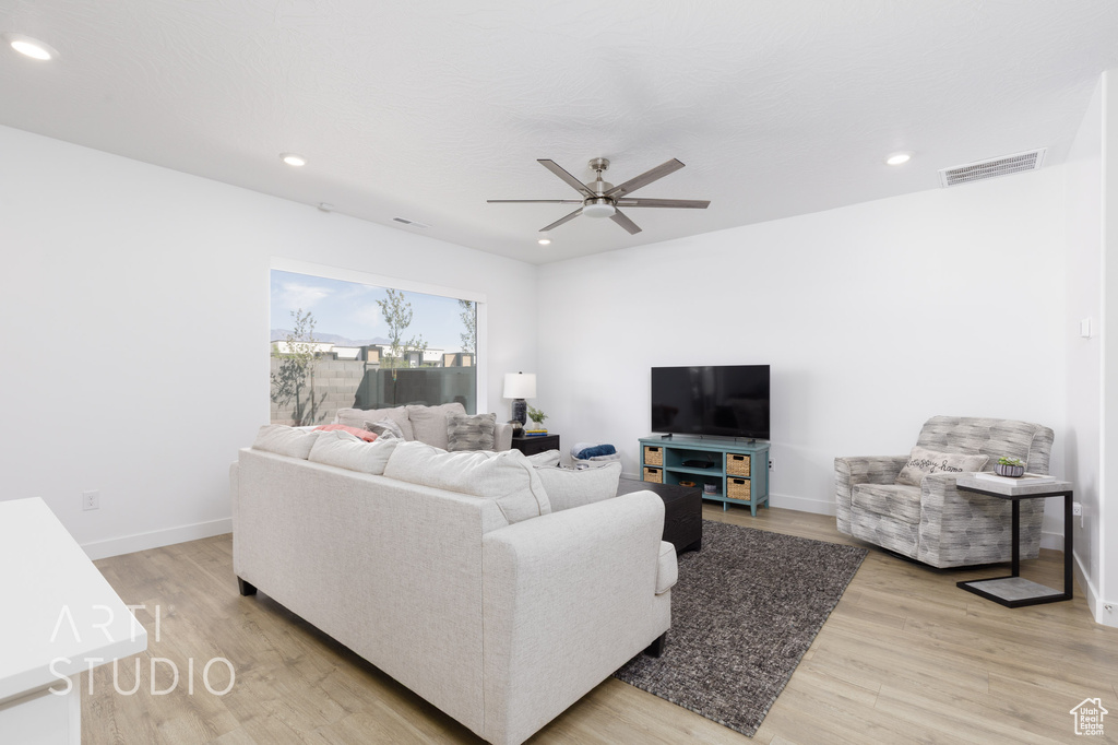 Living room featuring recessed lighting, visible vents, ceiling fan, and light wood-style flooring