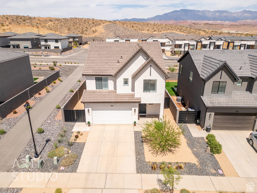 View of front of home featuring a residential view, concrete driveway, an attached garage, and stucco siding