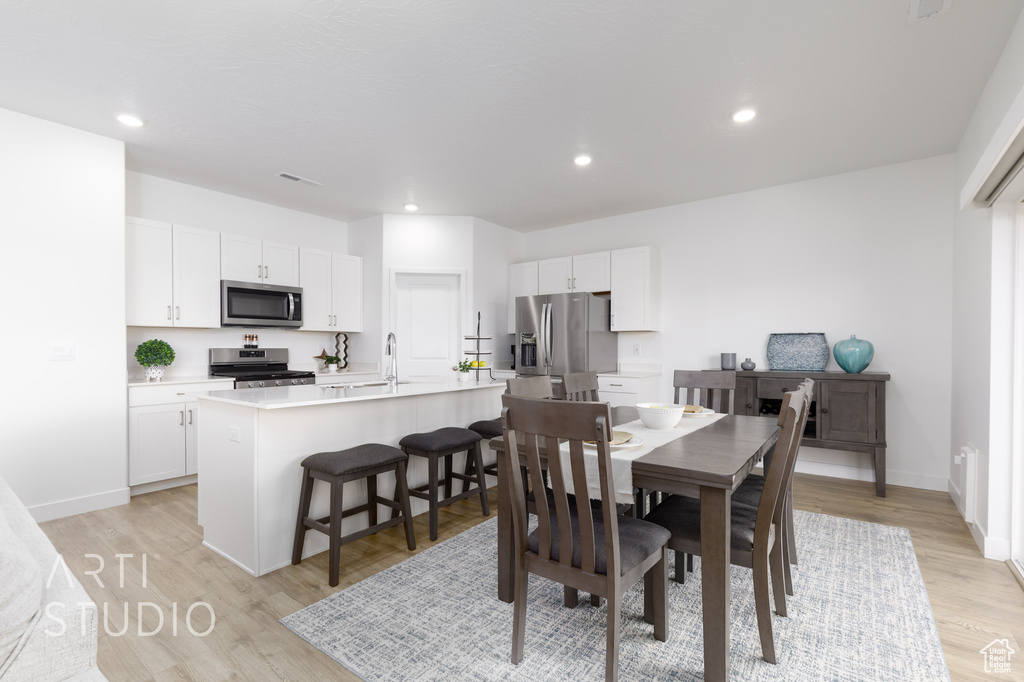 Dining room with baseboards, recessed lighting, and light wood-style flooring