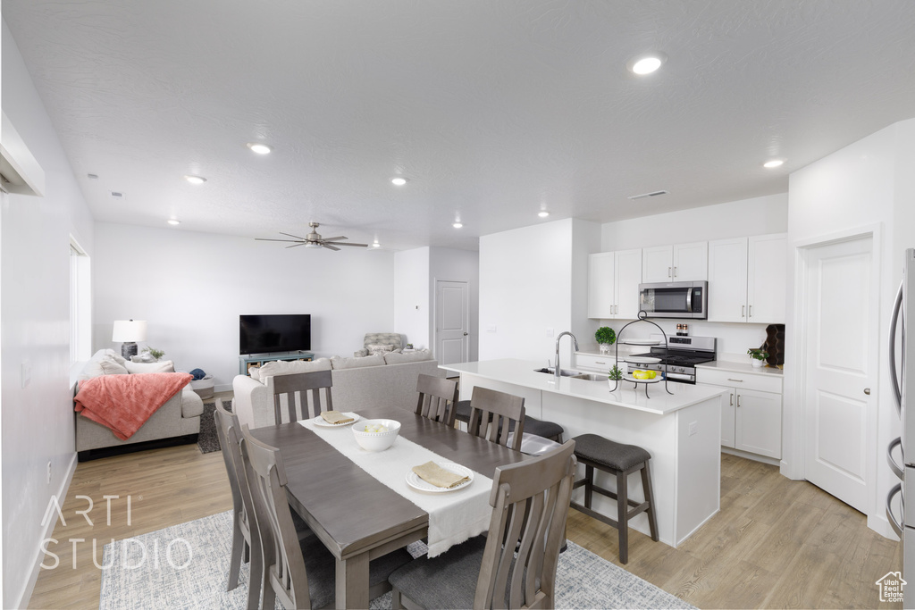 Dining area with light wood finished floors, recessed lighting, and a ceiling fan