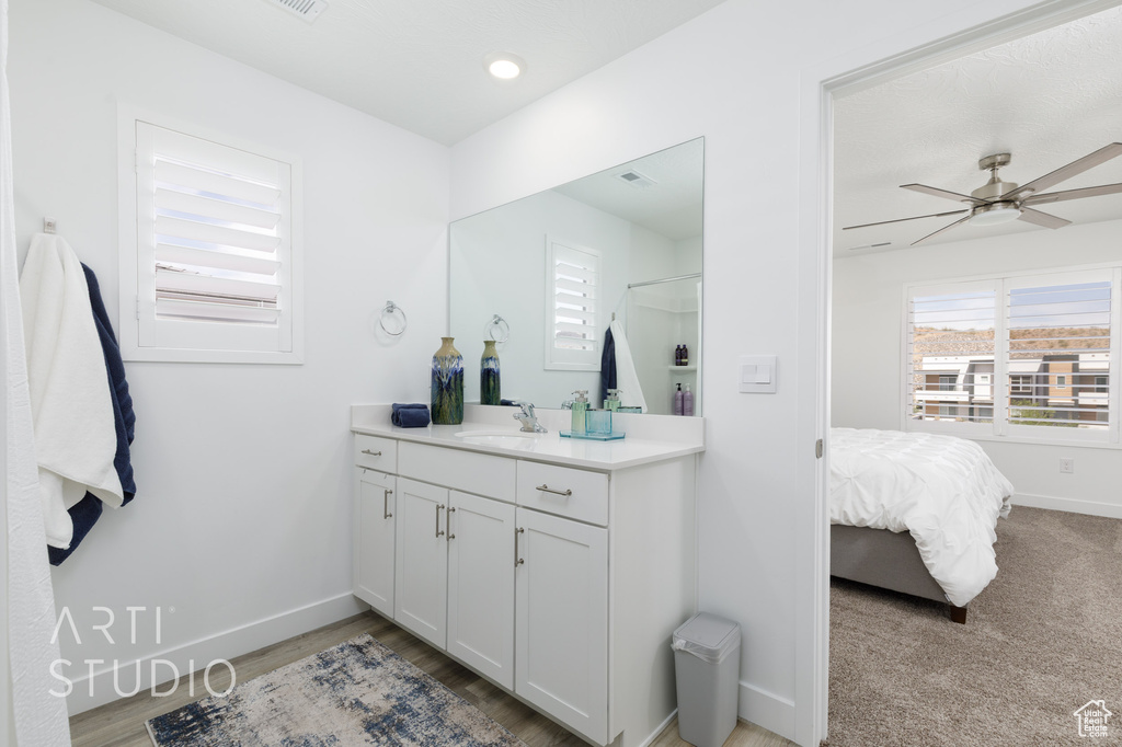 Full bath featuring wood finished floors, ceiling fan, vanity, baseboards, and visible vents