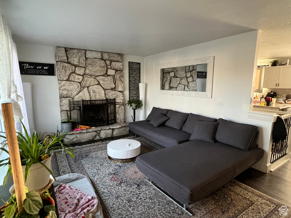 Living area with a stone fireplace and wood finished floors