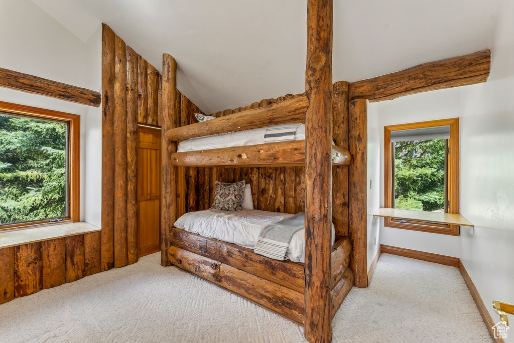 Bedroom with vaulted ceiling and carpet floors