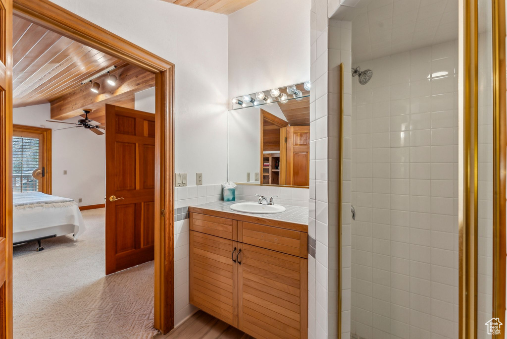 Ensuite bathroom with wooden ceiling, ensuite bath, a tile shower, vanity, and a ceiling fan