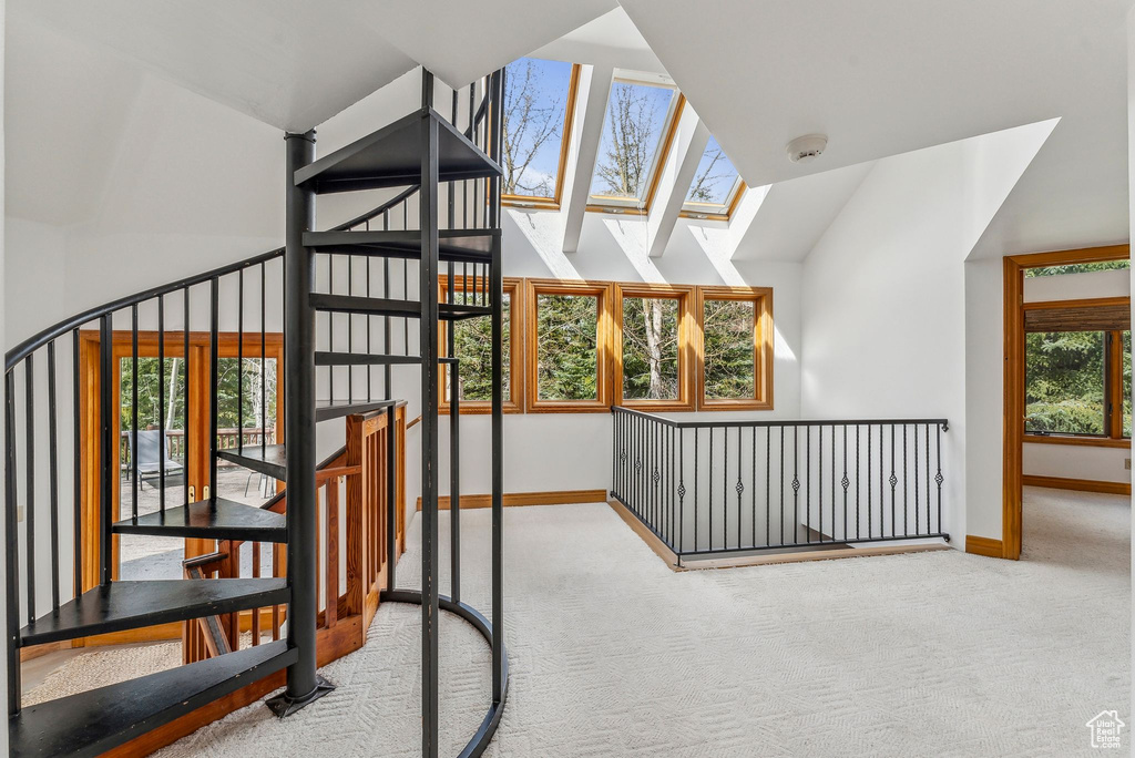 Interior space with a skylight, carpet flooring, and baseboards