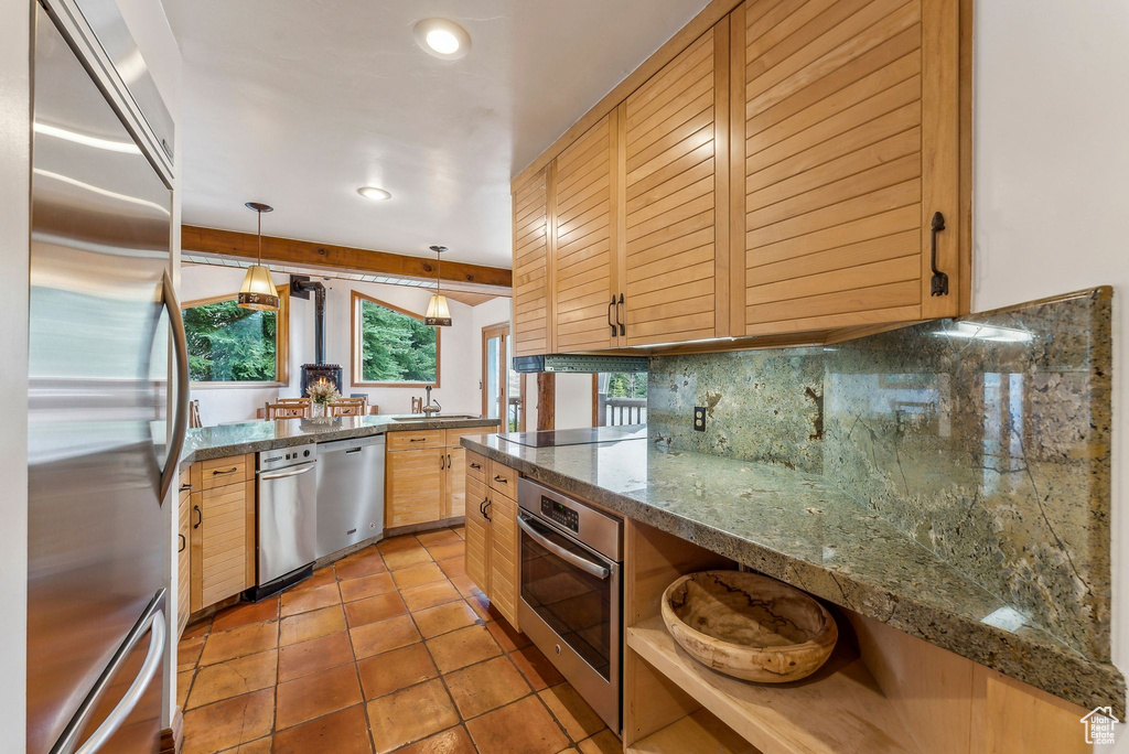 Kitchen with recessed lighting, a sink, stainless steel appliances, decorative backsplash, and light tile patterned floors