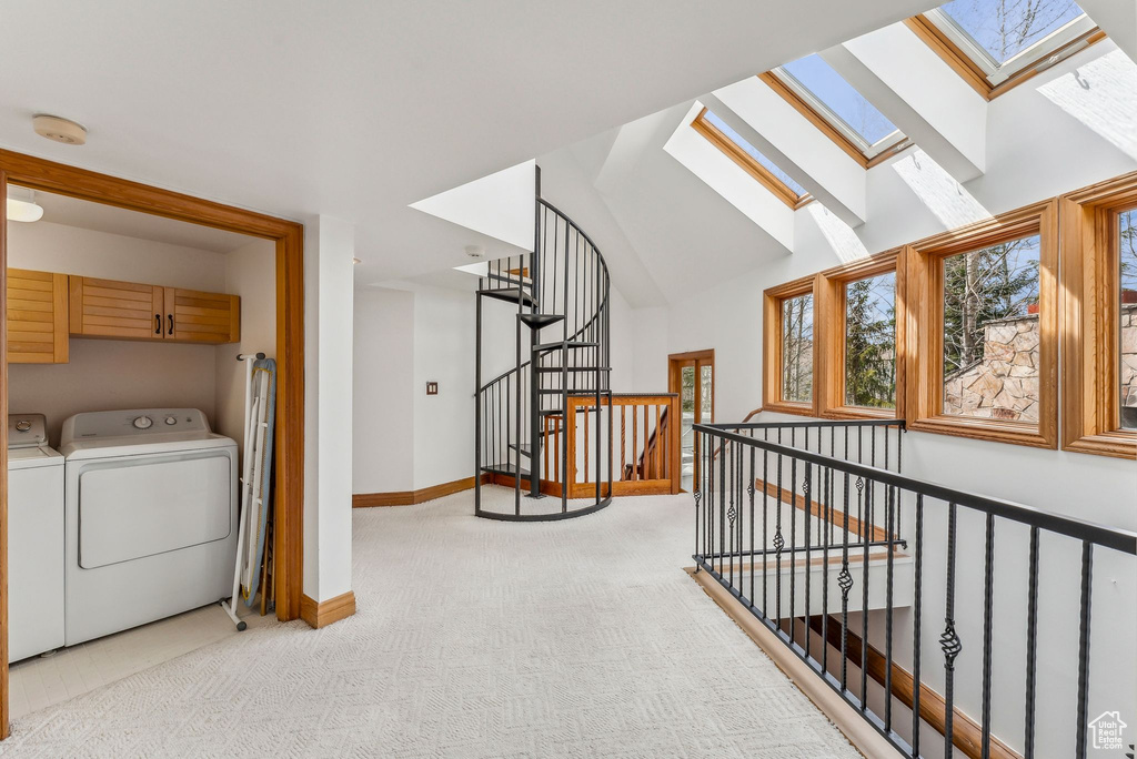 Bonus room with baseboards, a wealth of natural light, separate washer and dryer, and light colored carpet