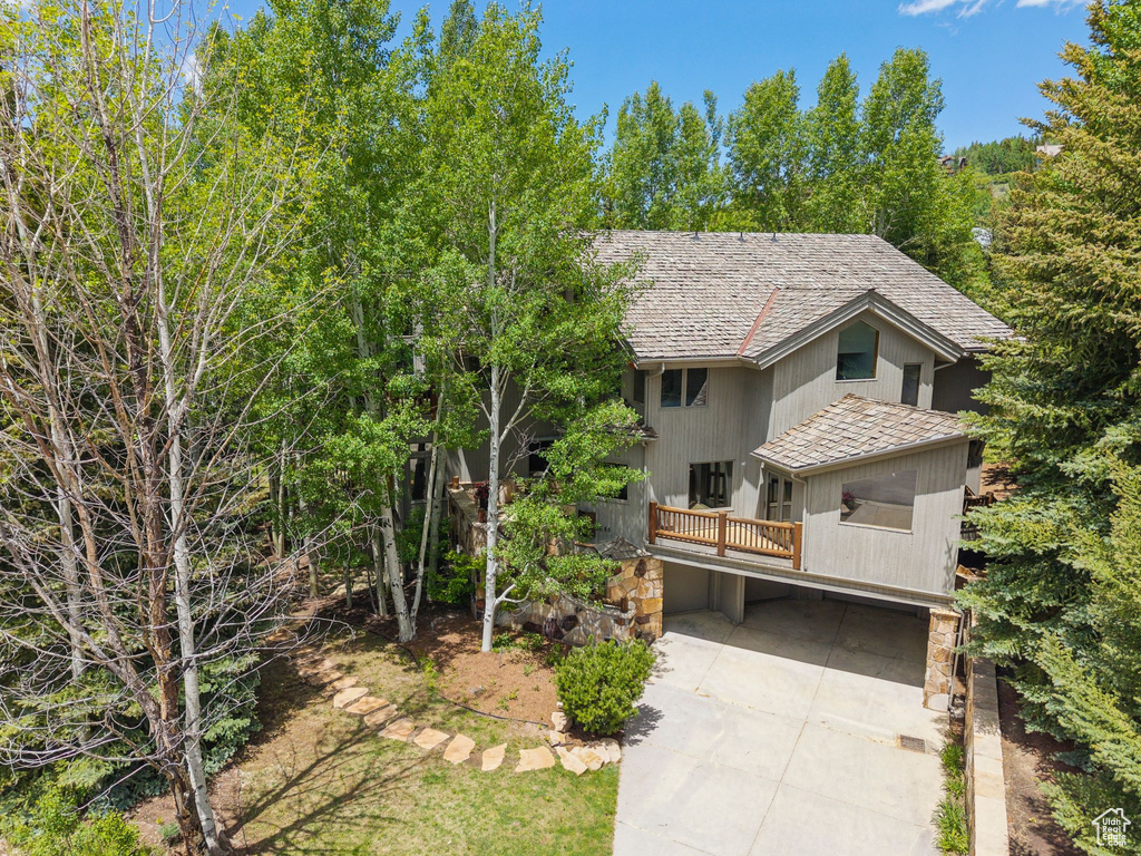 View of front of property featuring a shingled roof and concrete driveway