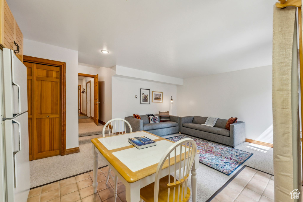 Living area with light tile patterned floors, recessed lighting, light colored carpet, and baseboards