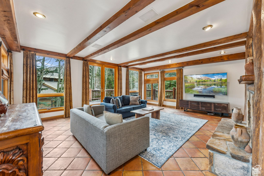 Living room with beamed ceiling, recessed lighting, light tile patterned floors, and baseboards