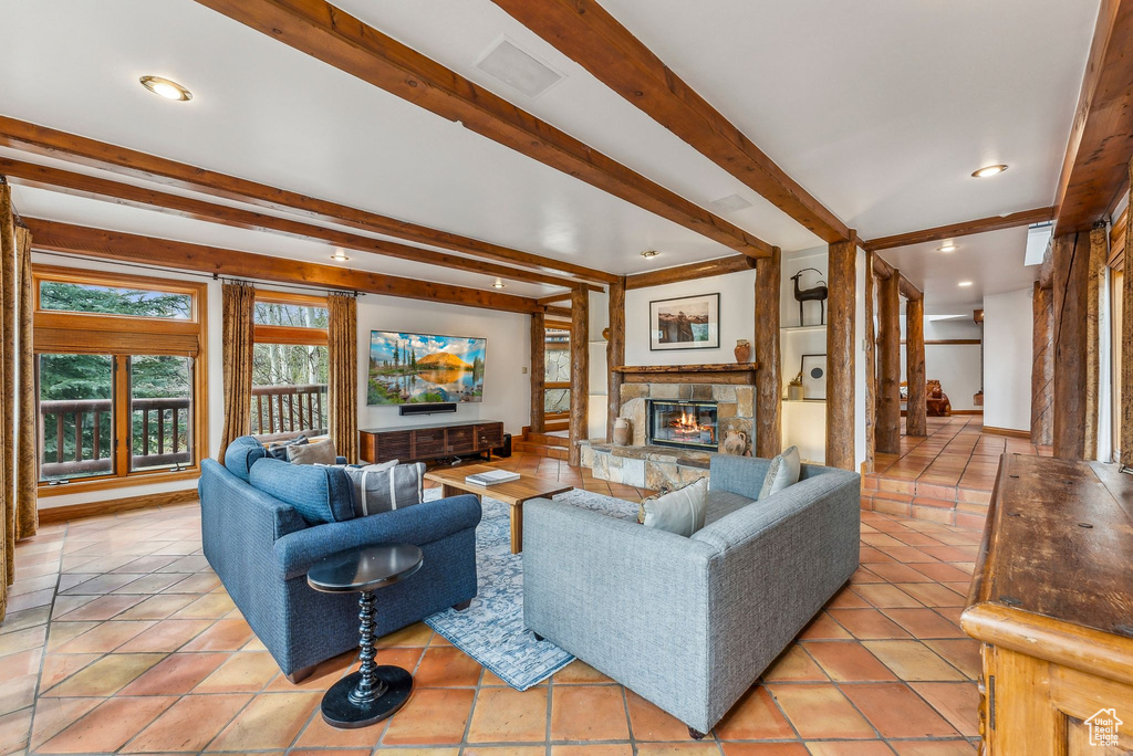 Living room featuring beamed ceiling, baseboards, light tile patterned flooring, recessed lighting, and a fireplace
