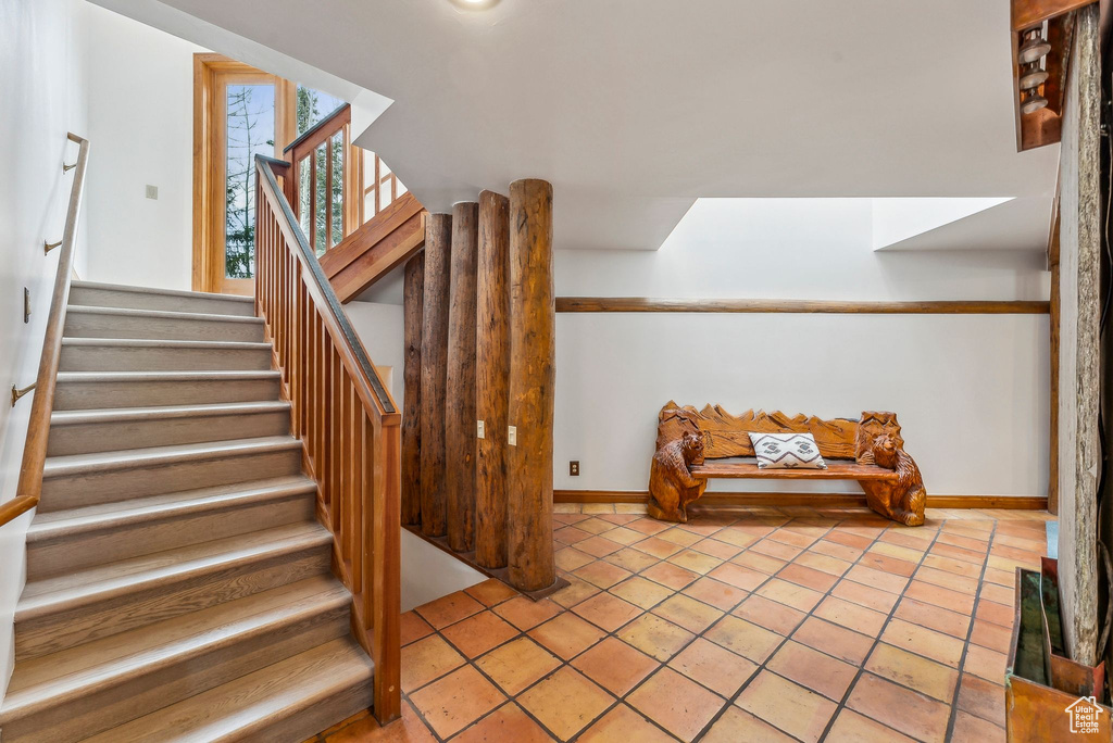 Stairs featuring tile patterned floors and baseboards