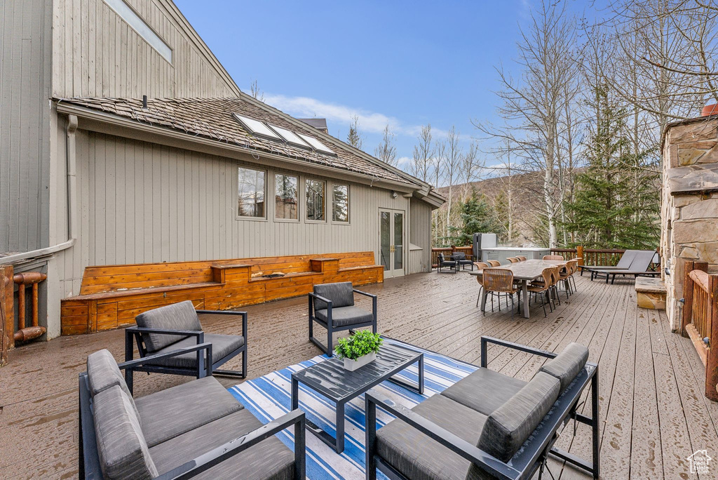 Wooden terrace with an outdoor living space and outdoor dining area